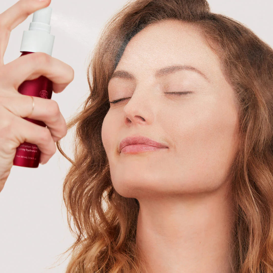 Woman with closed eyes receiving a facial mist from jane iredale Pommisst Hydration Spray.